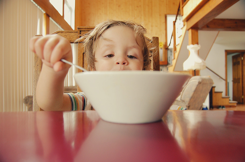 Toddler feeding himself from a large bowl